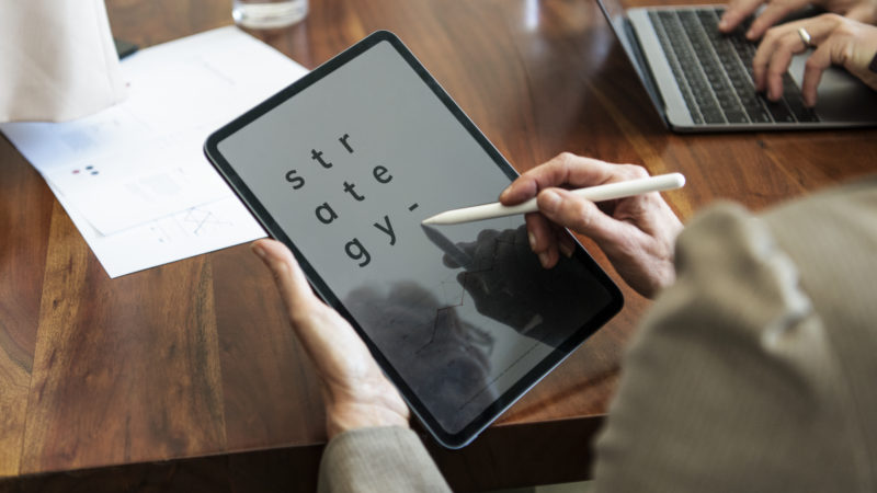Businessperson taking note on a digital tablet